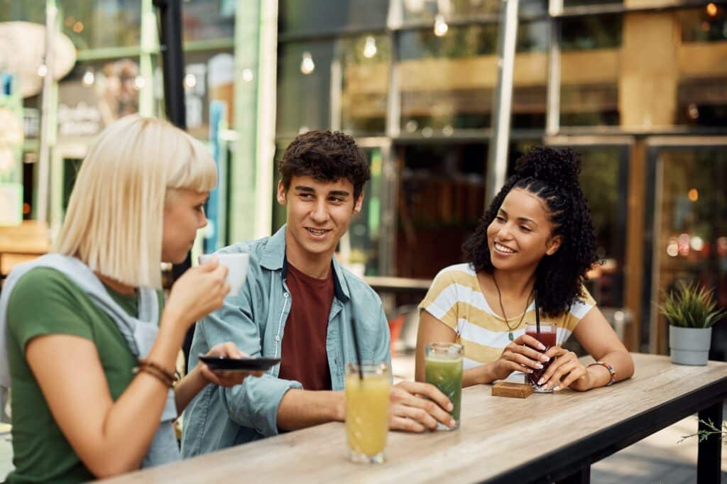 Group of young multiracial people communicating while relaxing in a cafe.